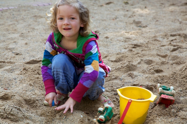 Im Sandkasten bauen die Kinder Sandburgen,Straßen undspielen an der Matschanlage. 