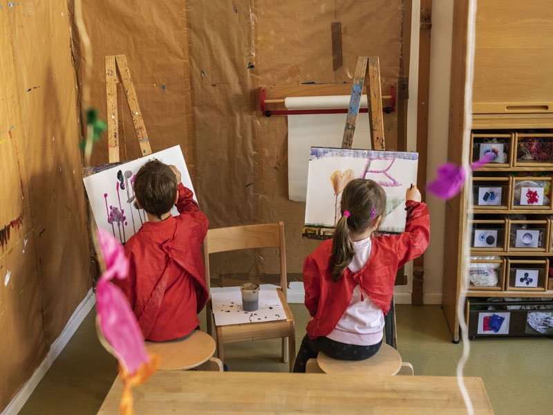Künstler an Staffeleien im Kinder Atelier.