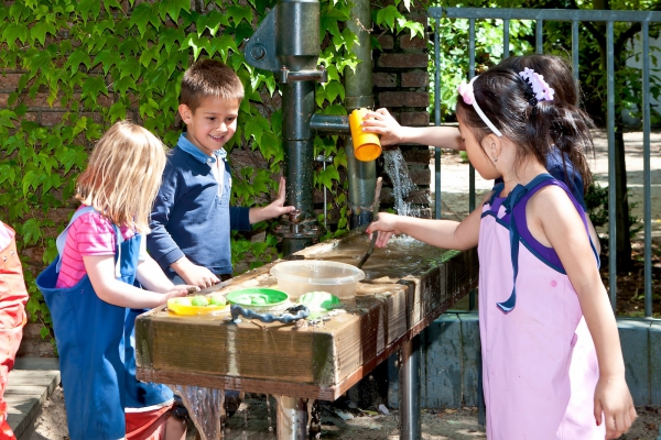 Ein Innenhof verfügt über eine Bewegungsfläche für Spiel-und Bewegungsaktionen, eine Sandfläche und Spielgeräte. Eine Wassermatschanlage lädt zum Experimentieren und Spielen ein.