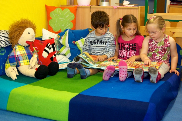 Auch das Vorlesen kommt in der gemütlichen Kuschelecke nicht zu kurz. Die Kinder entwickeln Phantasie sowie Freude am Erzählen und erweitern damit ihre sprachlichen Fähigkeiten.