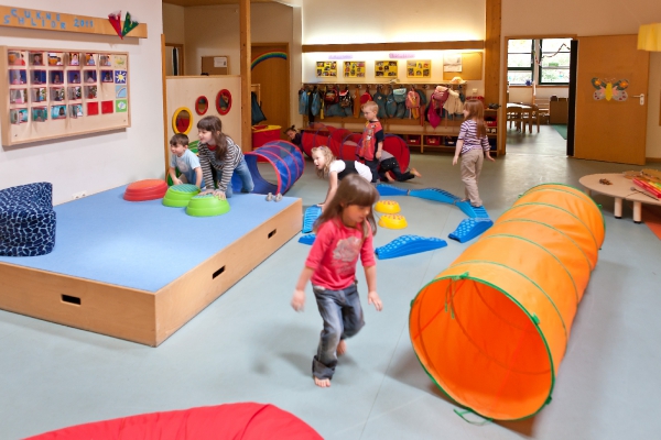 Eine große Halle, um die sich alle Gruppenbereiche gruppieren, bietet den Kindern im Freispiel ein vielfältiges und freies Bewegungsangebot.