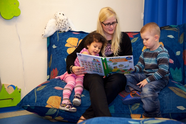Eine Bilderbuchbetrachtung in vertrauter Umgebung unterstützt die sprachliche Fähigkeit von Kindern.