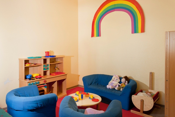 Der Rollenspielbereich im Flur, mit  "Kinderküche", gemütlicher Sitzecke, Schminktisch und einer großen Verkleidungskiste.