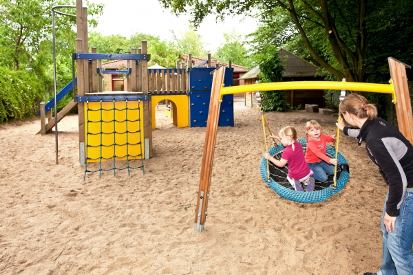 Spielgeräte wie die Nestschaukel nutzen die 2-jährigen Kinder sehr gern. Auch in den Gruppenräumen ist für das junge Kind anregungsreiches Material vorhanden, das zum Spiel auffordert.