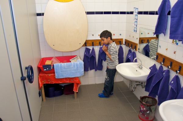 Auch in den Waschräumen stehen für die Kinder unterschiedliche Materialien griffbereit zur Verfügung. Sie experimentieren mit Wasser, stellen sich selbst Aufgaben und finden eigene Lösungen.
