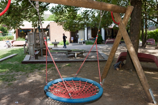 Den Kindern steht u.a. eine Nestschaukel und eine Matschanlage zur Verfügung, die im Hintergrund zu sehen ist.