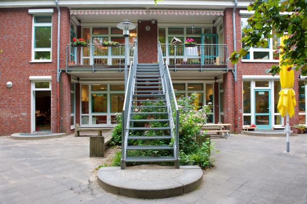 Hier die Rückansicht unseres Hauses.
Alle Gruppen haben bodentiefe Fenster und einen eigenen Zugang zum Garten.