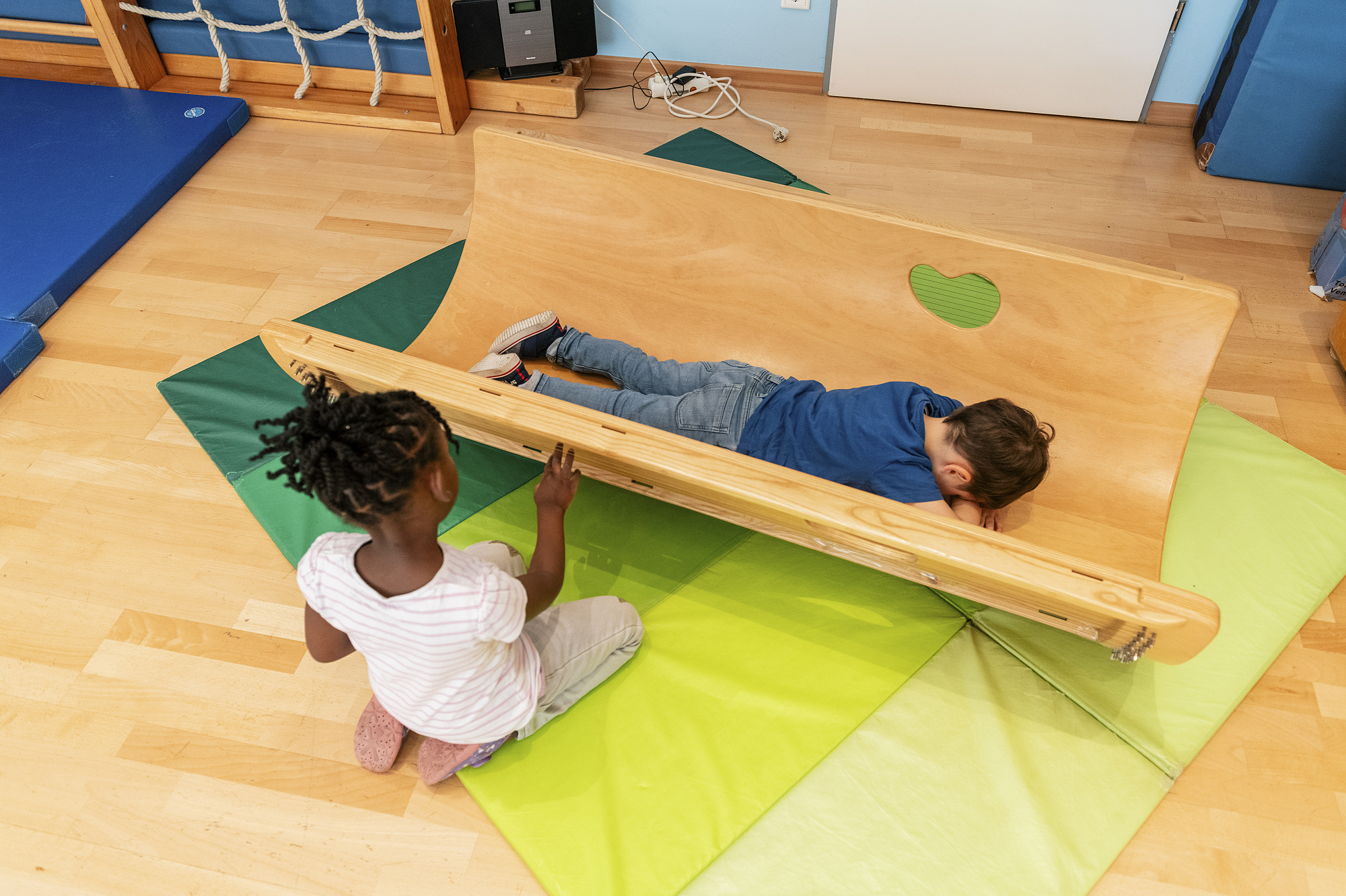 Im Turnraum bieten wir auch Entspannungseinheiten wie die Klangwiege, aber auch Bilderbuchbetrachtungen, Kinderyoga oder Entspannen mit Musik an.