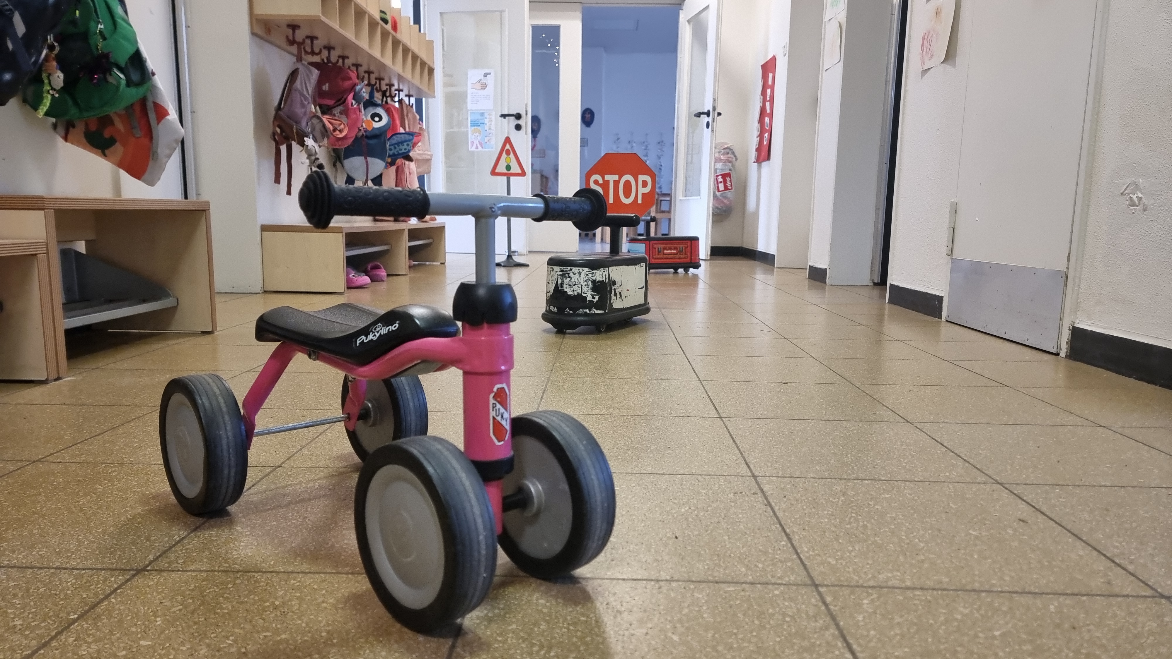 Hier ist einer der Gruppenflure zu sehen, wo sich die Garderoben der Kinder befinden und  den die Kinder zum Spielen mit nutzen können, wie zum Beispiel um mit den Fahrzeugen zu fahren.